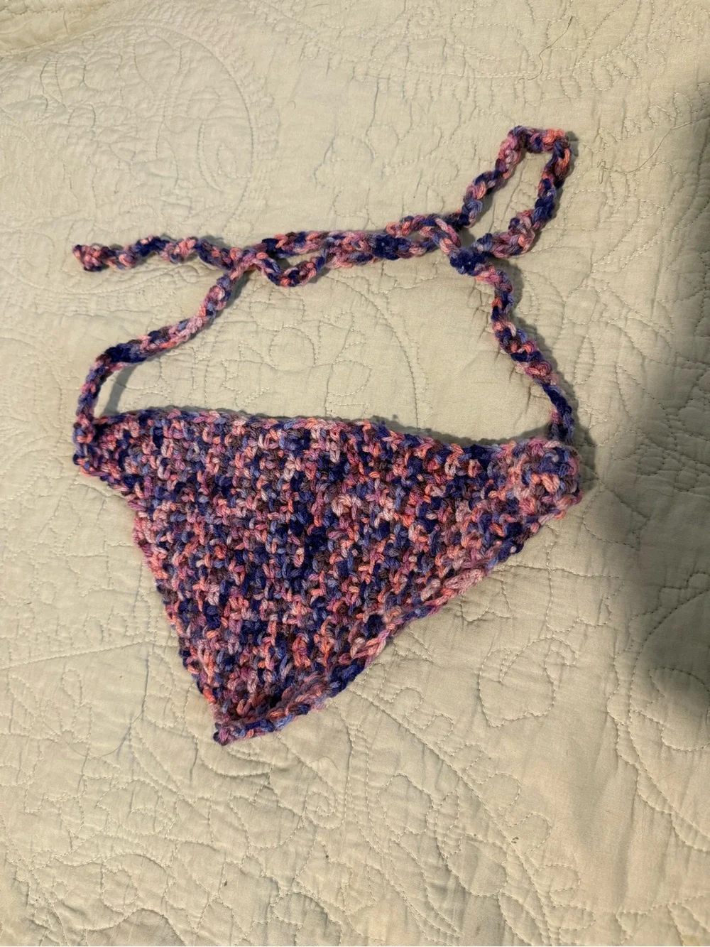 Handmade crochet bandana in pink, blue, and purple marbled yarn.